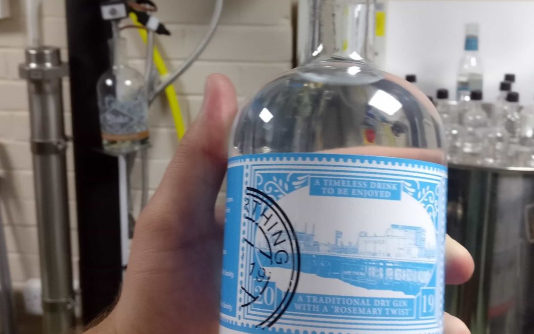 Tom holding a bottle of Worthing Gin in the distillery where it is made at Slake Spirits