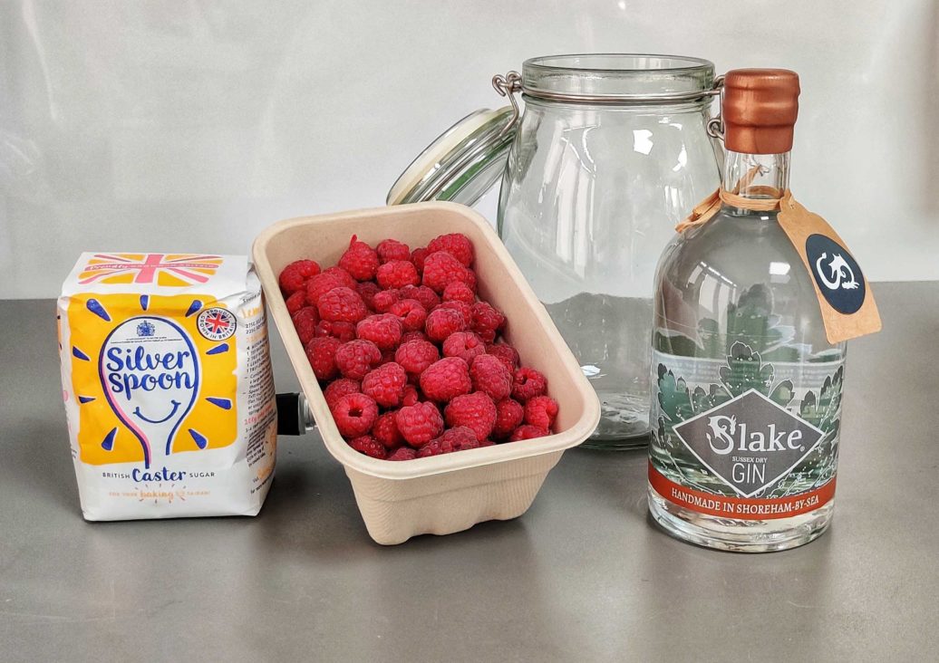 All the ingredients you need to make the best raspberry gin liqueur - caster sugar, fresh raspberries, airtight jar and Slake Sussex Dry Gin